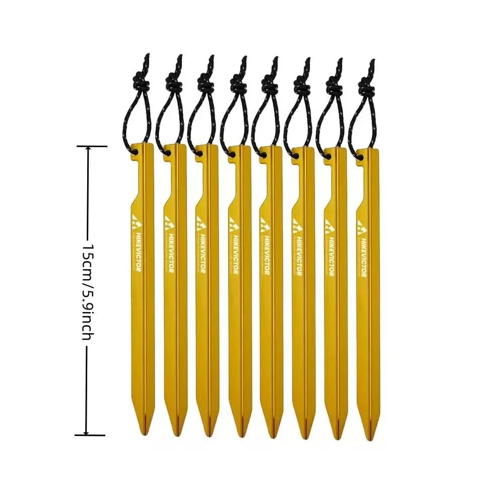 Neuf piquets de tente jaunes, marqués « Hikevictor - 15 cm » ou piquets de tente, mesurant 15 cm (5,9 pouces) chacun de longueur sont alignés côte à côte avec des cordons noirs attachés. Ils sont fabriqués à partir d'un alliage d'aluminium durable.