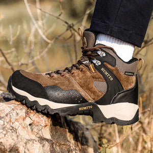 Les chaussures de randonnée mid-top "HUMTTO - HT-210337A" pour homme, 100% imperméables, offrent un design beige et noir, des chaussettes intégrées et des semelles antidérapantes, idéales pour l'expédition et la randonnée outdoor.