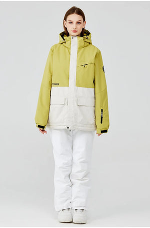 Une personne se tient debout, portant la tenue d'hiver bicolore « Artic King - Queen 105 », composée d'une veste verte et d'un pantalon blanc en polyester, sur un fond neutre.