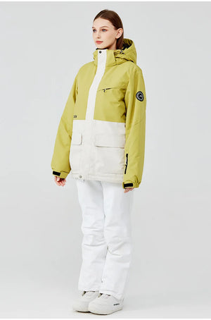 Une personne portant la combinaison d'hiver verte et blanche « Artic King - Queen 105 » pour le ski et le snowboard, conçue pour être imperméable et coupe-vent par Artic King, se tient debout sur un fond uni, accompagnée d'un pantalon et de chaussures en polyester blanc.