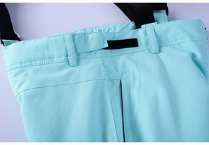 Gros plan du pantalon de ski et de snowboard d'hiver unisexe bleu clair « Artic King - Queen 105 » en polyester, doté d'une ceinture noire avec passants de ceinture, d'une sangle velcro et d'une fermeture éclair.