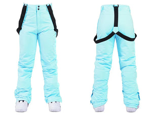 Le pantalon de neige bleu clair « Artic King - Queen 105 », fabriqué en polyester durable et doté de bretelles noires réglables, est élégamment présenté de devant et de derrière avec une élégante association de bottes de neige blanches.