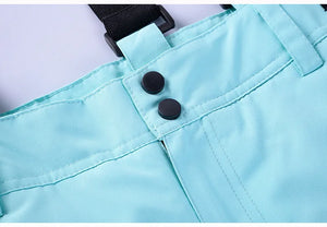 Gros plan du pantalon de ski et de snowboard d'hiver en polyester turquoise « Artic King - Queen 105 » avec fermetures à boutons noirs et passants de ceinture, conçu par Artic King.