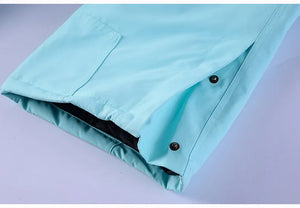 Gros plan d'une manche en polyester bleu clair de la combinaison de ski et de snowboard d'hiver « Artic King - Queen 105 », dotée de boutons-pression et d'une poche visible, adaptée à un Artic King.