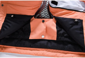 Gros plan d'une veste en polyester orange « Artic King - Queen 105 » avec un devant ouvert, révélant des poches intérieures doublées de noir et d'argent et des boutons-pression.