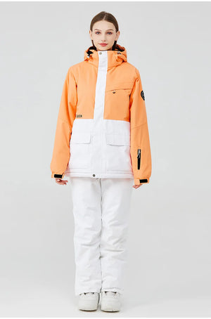 Une personne portant la veste d'hiver orange et blanche vibrante « Artic King - Queen 105 », fabriquée en polyester de qualité supérieure, se tient avec confiance sur un fond uni, associée à un pantalon et des chaussures blancs élégants.