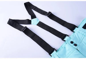 La combinaison d'hiver unisexe « Artic King - Queen 105 » pour le ski et le snowboard, conçue en polyester durable bleu clair avec bretelles et boutons réglables noirs, est présentée à plat sur un fond clair.