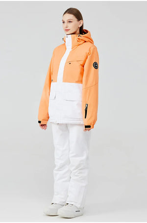 Une personne porte la combinaison d'hiver unisexe imperméable et coupe-vent « Artic King - Queen 105 », composée d'une veste orange et blanche en polyester durable, avec un pantalon et des bottes blancs assortis, debout sur un fond uni.