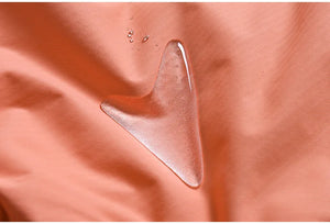 Gros plan de gouttes d'eau sur la surface lisse en tissu polyester couleur corail de la combinaison de ski et de snowboard d'hiver unisexe imperméable et coupe-vent Artic King, « Artic King - Queen 105 ».