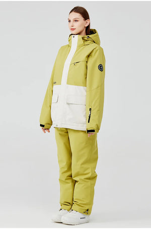 Vêtue de la tenue d'hiver unisexe « Artic King - Queen 105 », une personne se tient debout sur un fond uni. Cette tenue comprend une veste à capuche verte et blanche et un pantalon assorti confectionné en polyester, accompagnés de chaussures blanches, capturant parfaitement le style Artic King.