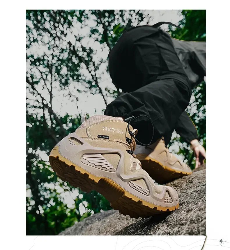 Une personne portant des "Bottes tactiques imperméables et respirantes pour homme Y0711" de Hunting Chaoying avec des semelles épaisses et un pantalon noir escalade une surface rocheuse à l'extérieur, des arbres visibles en arrière-plan.