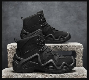 Bottes tactiques imperméables et respirantes pour homme "Hunting Chaoying - Y0711" de la marque Hunting Chaoying, noires, hautes, à semelles robustes, exposées sur des blocs de béton devant un fond gris.