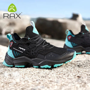 Chaussures de trail homme Rax 91-5C485 noires et turquoise, mesh respirant, FREE FLEXIBLE, posées sur rochers en extérieur.