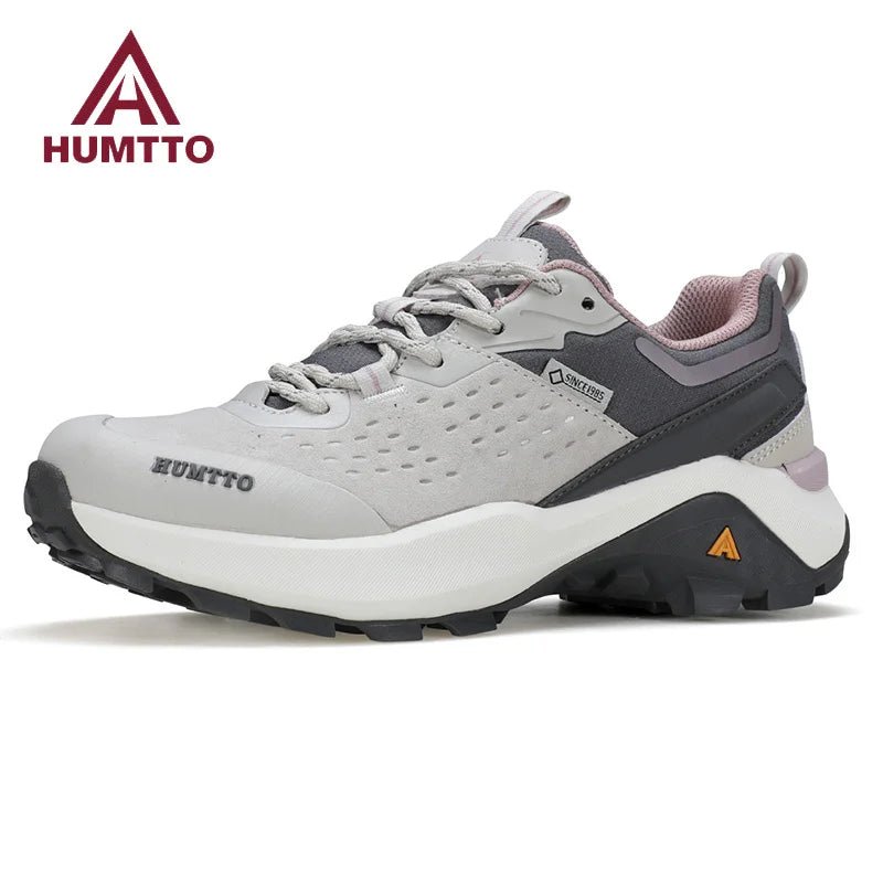 Chaussures de randonnée / trail low-top pour femme "HUMTTO - HT-160560B" grises et blanches en cuir véritable, semelle noire, accents roses, logo Humtto sur le côté et le dessus-idéales pour la randonnée.