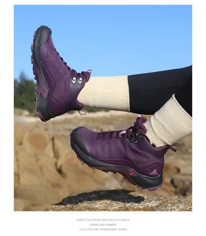 Une chaussure de randonnée pour femmes HUMTTO - HT-220838B violette avec protection contre les éclaboussures, semelle robuste, soutien de la cheville et système de laçage rapide, représentée sur un fond blanc avec le logo Humtto dans le coin supérieur gauche.