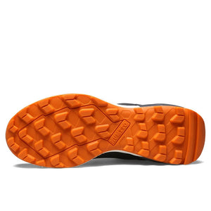 Les chaussures de randonnée Humtto HT-220838A pour hommes sont dotées d'une protection contre les éclaboussures, d'un système de laçage à cadran, d'un design gris et noir avec une bande de roulement orange, de logos visibles, et sont des chaussures de randonnée parfaites pour les sentiers accidentés.