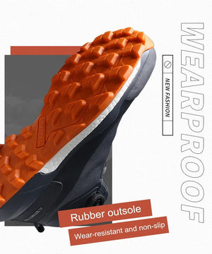 Les chaussures de randonnée Humtto HT-220838A pour hommes sont dotées d'une protection contre les éclaboussures, d'un système de laçage à cadran, d'un design gris et noir avec une bande de roulement orange, de logos visibles, et sont des chaussures de randonnée parfaites pour les sentiers accidentés.