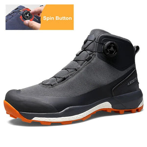 Les chaussures de randonnée Humtto HT-220838A pour hommes sont dotées d'une protection contre les éclaboussures, d'un système de laçage à cadran, d'un design gris et noir avec une bande de roulement orange, de logos visibles, et sont des chaussures de randonnée parfaites pour les sentiers accidentés.