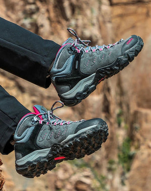 Les HUMTTO - HT-290027B mid-top randonnée bottines pour femme, en gris et noir avec accents roses, sont présentées en angle sur fond blanc. Elles offrent une protection splash-proof et une semelle antidérapante pour plus d'adhérence.