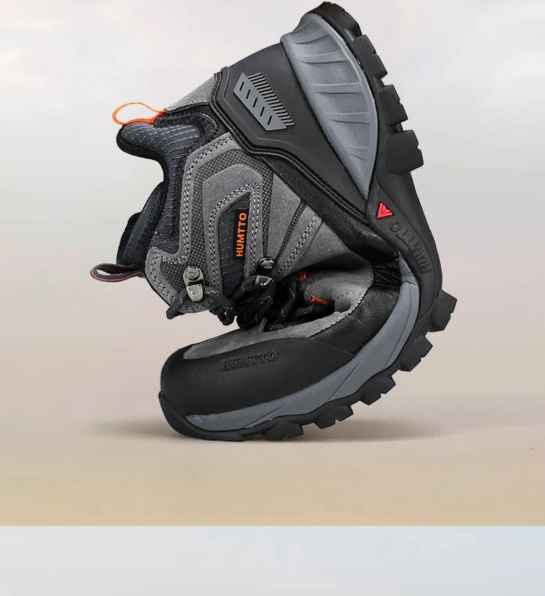 Chaussure de randonnée gris et noir Humtto "HT-250486A" pour homme, avec des accents orange, du cuir véritable, des œillets métalliques, une semelle robuste et la technologie Static Waterproof, montrée de profil sur fond blanc.