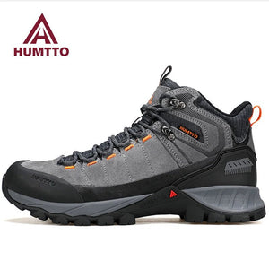 Chaussure de randonnée gris et noir Humtto "HT-250486A" pour homme, avec des accents orange, du cuir véritable, des œillets métalliques, une semelle robuste et la technologie Static Waterproof, montrée de profil sur fond blanc.
