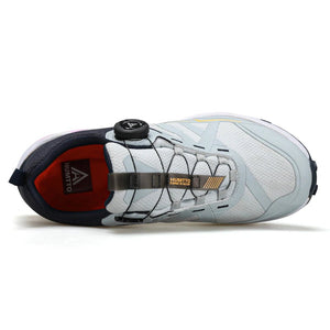 Chaussures de trail Humtto "RKT Explosive force" pour femmes, blanches et grises, avec semelle noire, accents jaunes et roses, laçage à bouton tournant et technologie Event® Dynamic Waterproof.