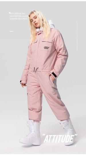 Mannequin en combinaison de ski imperméable Copozz Jump suit 21306 rose clair et bottes blanches devant fond uni.