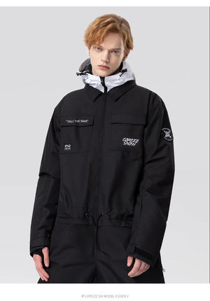 Une personne aux cheveux clairs porte la combinaison de ski imperméable Copozz Jump suit 21306 sur fond gris clair.