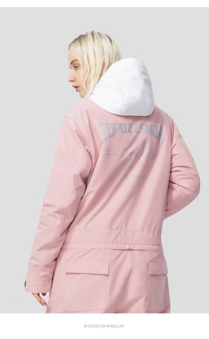 Personne blonde de dos en combinaison de ski Copozz Jump suit 21306 imperméable rose et blanche pour snowboarders.