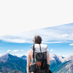 Une personne avec un Sac à dos de randonnée / trekking imperméable UHMWPE 40L + 16L 920g "Qi Dian Pro", face au paysage de montagne à couper le souffle sous un ciel clair.