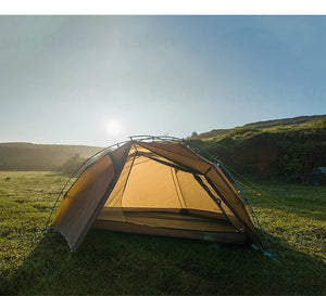 Une tente 3F UL GEAR - Taiji 1, fabriquée en nylon Ripstop résistant, est installée sur un terrain herbeux sous un ciel bleu clair. Le soleil est bas, projetant une lueur chaleureuse sur la scène sereine. Pesant seulement 1,45 kg, cette tente de bikepacking ultra-légère résiste parfaitement à toutes les conditions météorologiques.