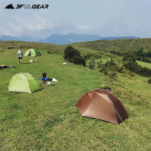 Sous un ciel dégagé sur une colline herbeuse, la tente 3F UL GEAR - Taiji 1 se dresse avec résilience face aux montagnes majestueuses. Fabriquée en nylon Ripstop durable et avec des poteaux en aluminium, elle est parfaite pour les aventuriers solitaires qui découvrent la tranquillité de la nature au fil des quatre saisons.