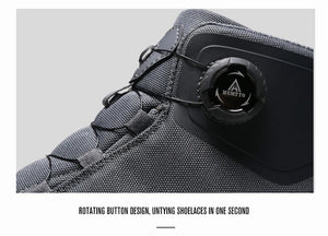 Les chaussures de randonnée Humtto HT-220838A pour hommes sont dotées d'une protection contre les éclaboussures, d'un système de laçage à cadran, d'un design gris et noir avec une bande de roulement orange, de logos visibles, et sont des chaussures de randonnée parfaites pour les sentiers accidentés.