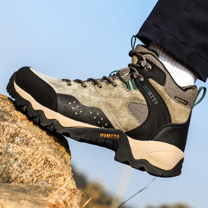 Les chaussures de randonnée mid-top "HUMTTO - HT-210337A" pour homme, 100% imperméables, offrent un design beige et noir, des chaussettes intégrées et des semelles antidérapantes, idéales pour l'expédition et la randonnée outdoor.