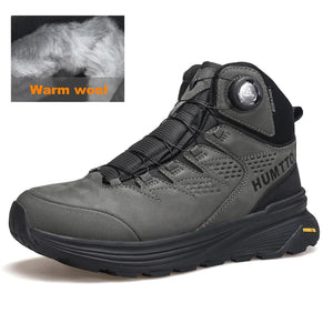 La HUMTTO - HT-240217C est une chaussure de randonnée mid-top noire pour homme avec cuir de vache durable, doublure polaire, technologie Static Waterproof, semelle épaisse, côtés texturés et système de laçage à molette, présentée sur un fond blanc.