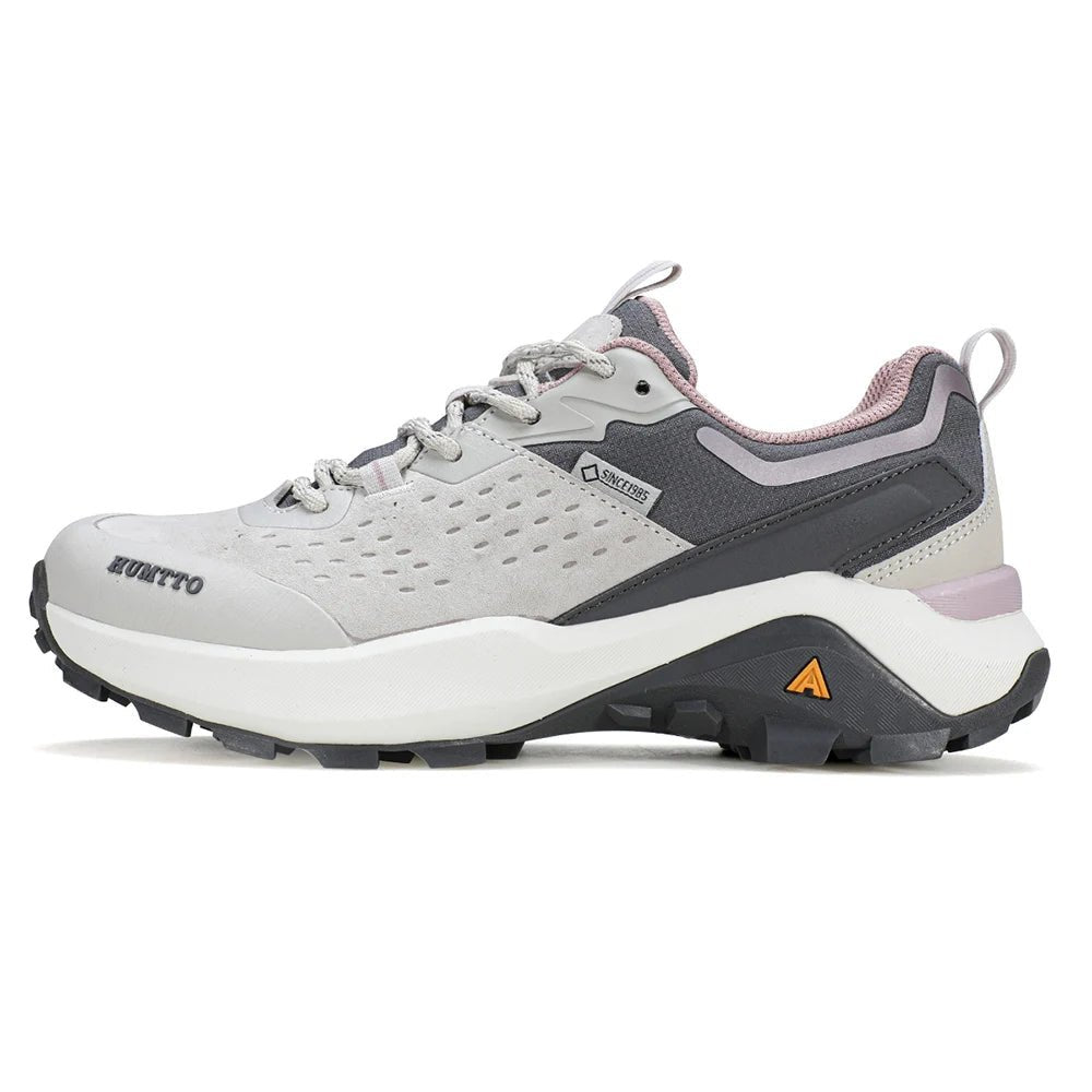 Chaussures de randonnée / trail low-top pour femme "HUMTTO - HT-160560B" grises et blanches en cuir véritable, semelle noire, accents roses, logo Humtto sur le côté et le dessus-idéales pour la randonnée.