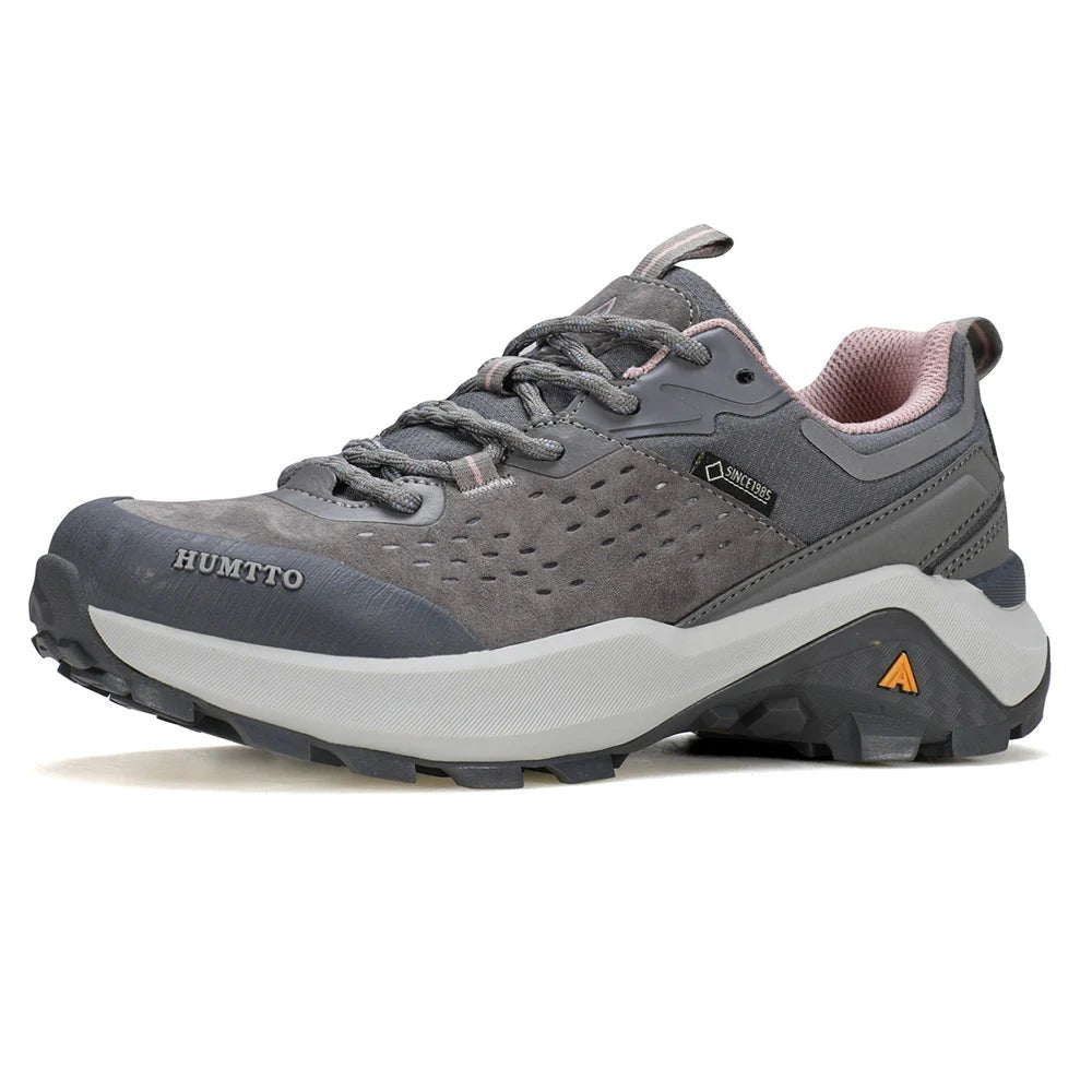 Chaussures de randonnée / trail low-top pour femme "HUMTTO - HT-160560B" grises et blanches en cuir véritable, semelle noire, accents roses, logo Humtto sur le côté et le dessus-idéales pour la randonnée.