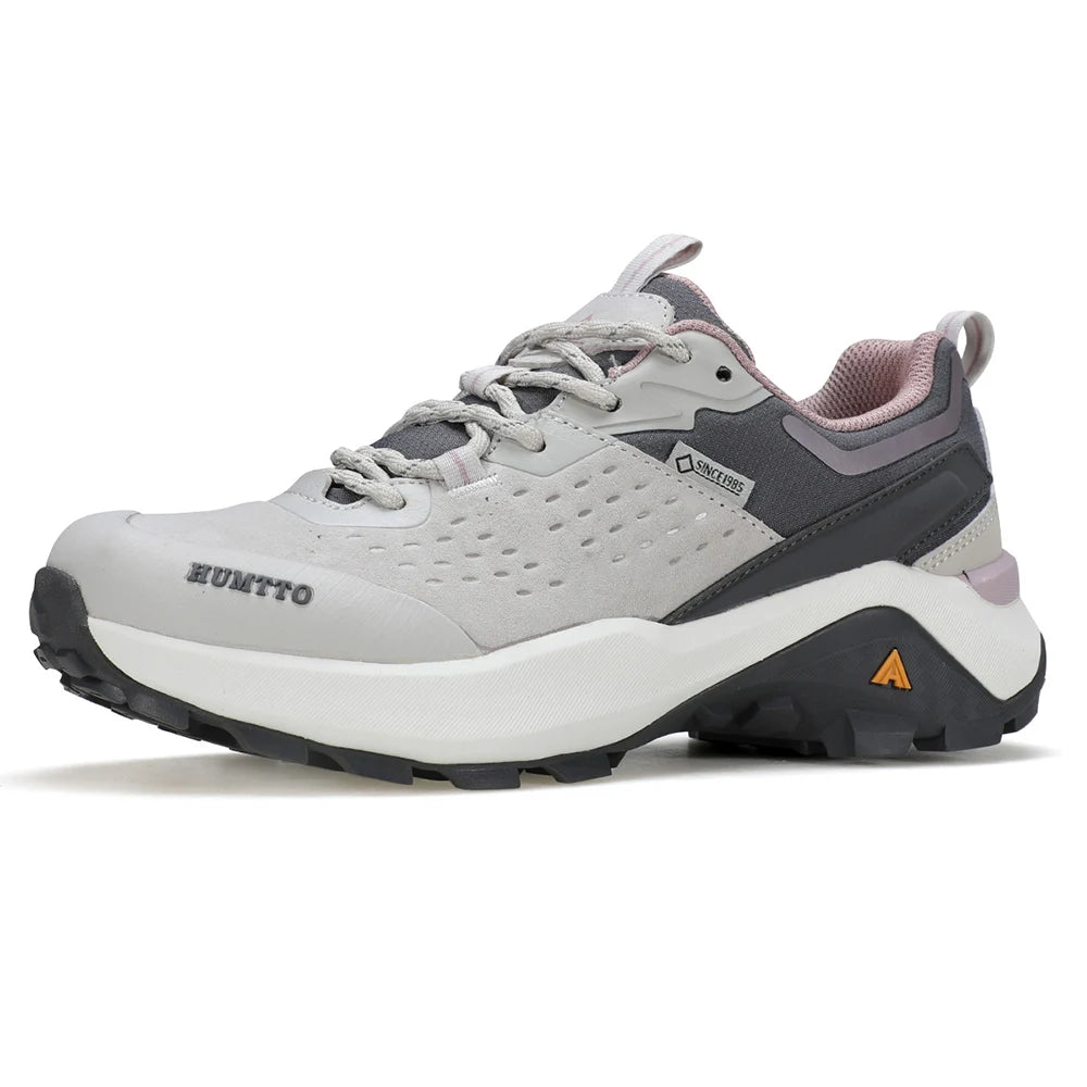 Chaussures de randonnée / trail low-top pour femme "HUMTTO - HT-160560B" grises et blanches en cuir véritable, semelle noire, accents roses, logo Humtto sur le côté et le dessus-idéales pour la randonnée.