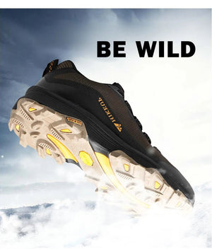 Chaussure randonnée basse HIKEUP HK-15 noir et jaune, HikGrip, Splash-proof, devant ciel nuageux, texte BE WILD.