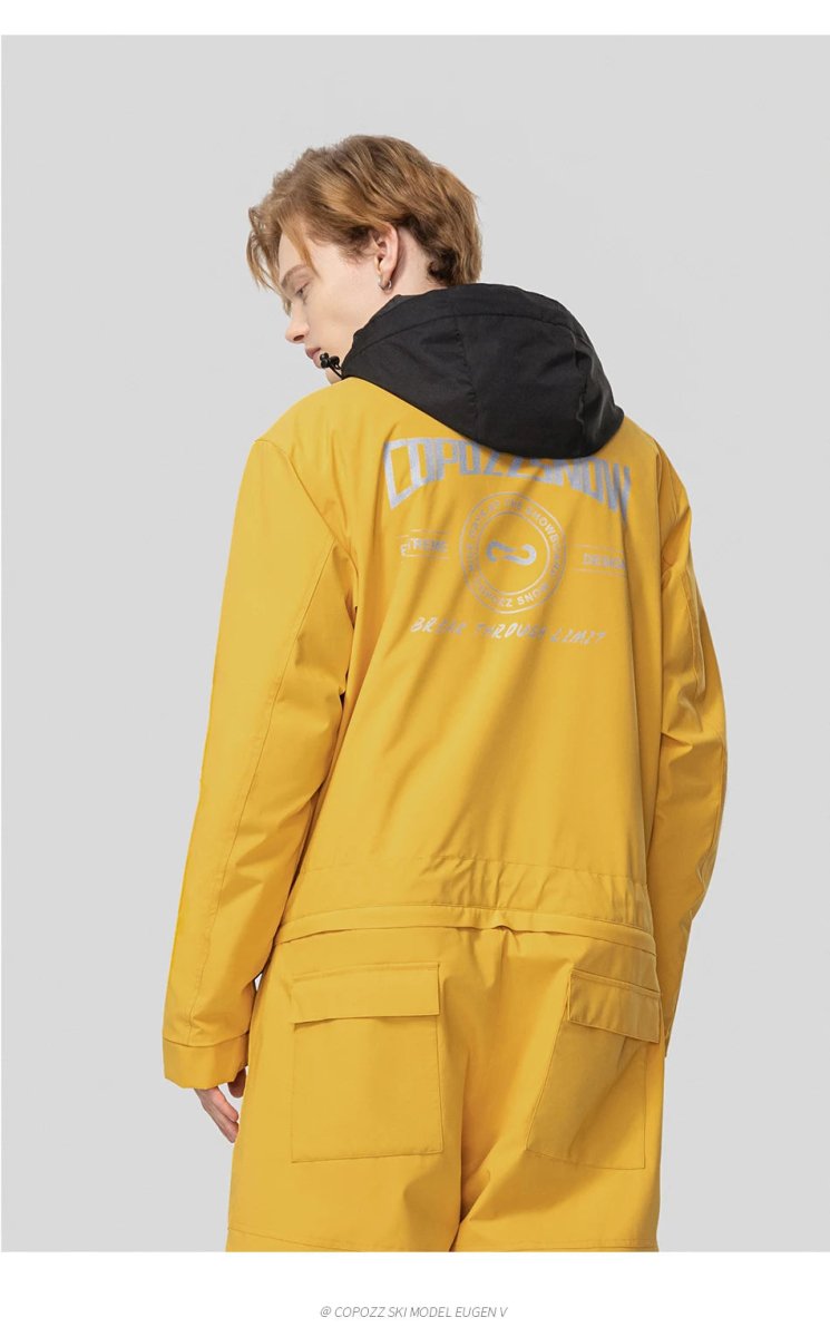 Personne de dos en veste de ski Copozz jaune modèle Jump suit 21306 à capuche noire, texte blanc outdoor au dos.