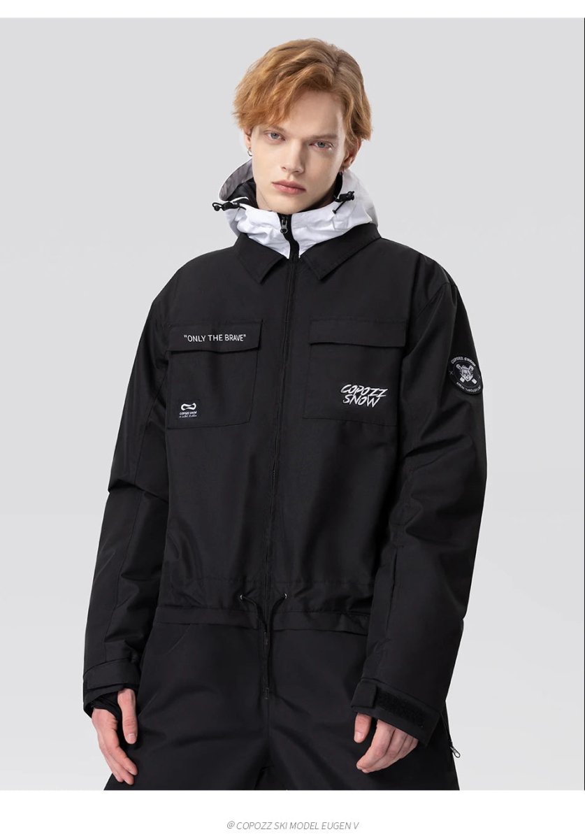 Une personne aux cheveux clairs porte la combinaison de ski imperméable Copozz Jump suit 21306 sur fond gris clair.