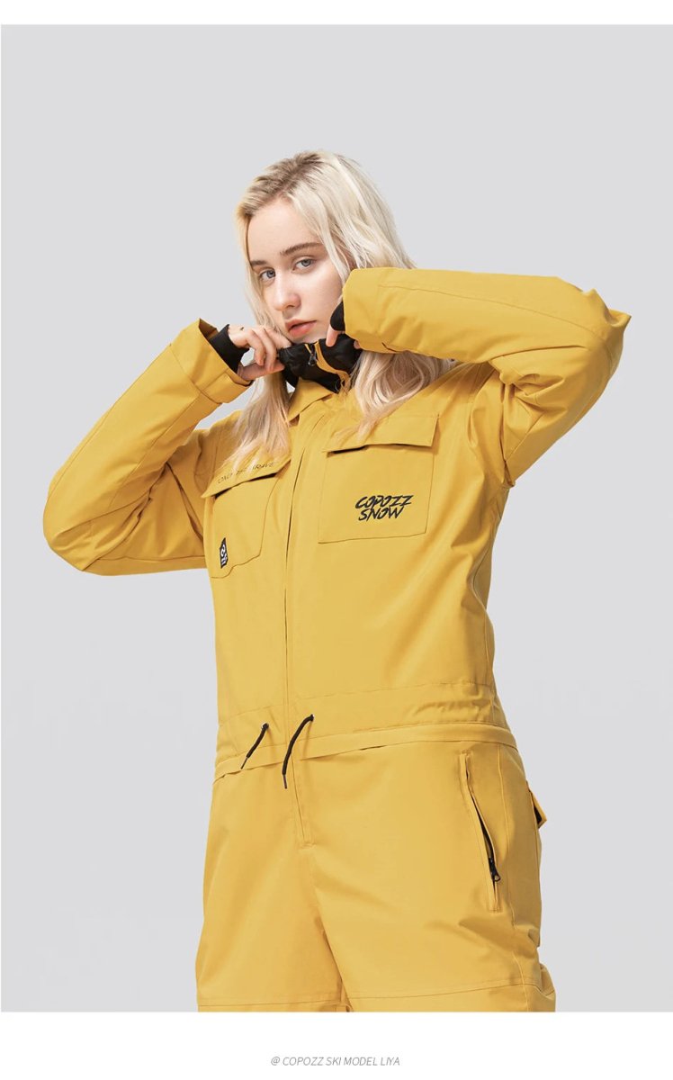 Personne aux longs cheveux blonds en veste de ski Copozz jaune Jump suit 21306, ferme la fermeture éclair, fond clair.