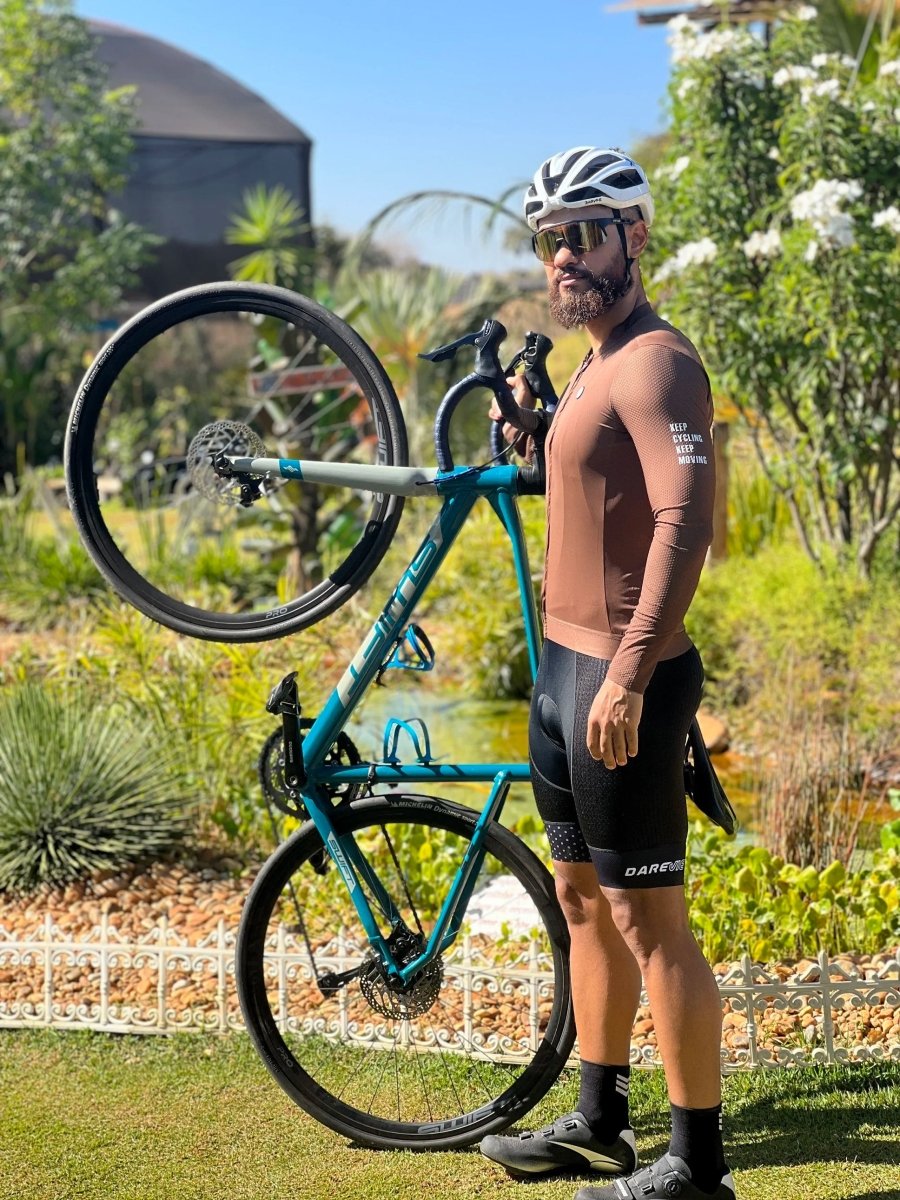 Le maillot de cyclisme unisexe à manches longues blanc DAREVIE "DVJ187" est doté d'une protection UV-SPF30+/SPF50+, d'une fermeture éclair sur le devant, de logos discrets, d'un tissu respirant et de manches en maille 3D pour plus de confort. Montré sur un fond uni.