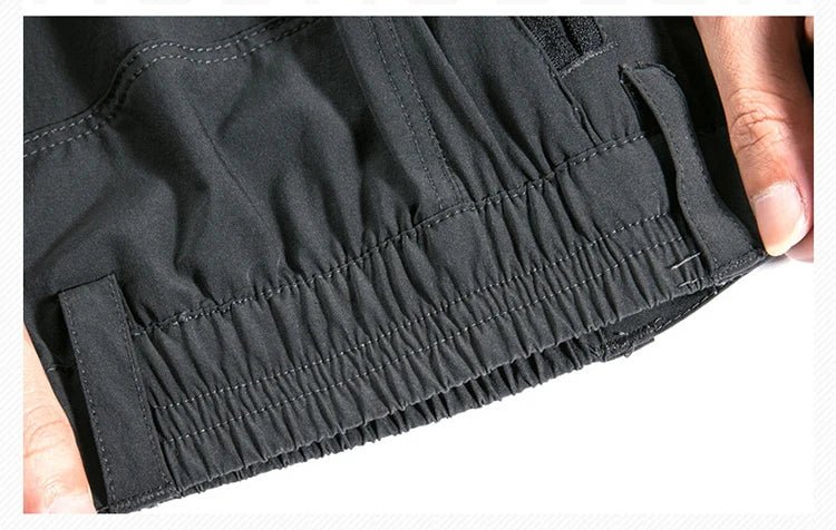 Gros plan sur des mains tenant la ceinture du pantalon de randonnée TRVLWEGO AD083 2 en 1 avec short amovible outdoor.