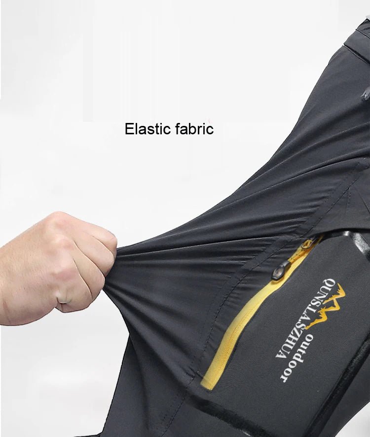 Main tirant un tissu élastique noir près dune poche zippée jaune, pantalon randonnée 2 en 1 TRVLWEGO, déperlant et séchage rapide.