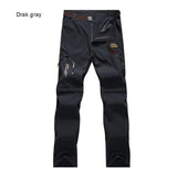 Pantalon de randonnée TRVLWEGO 2 en 1 gris foncé, poches zippées, logo Outdoor, séchage rapide, short amovible.
