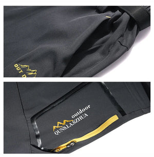 Gros plan sur le pantalon de randonnée 2 en 1 TRVLWEGO AD083 homme noir, zips jaunes, logo montagne, short amovible.